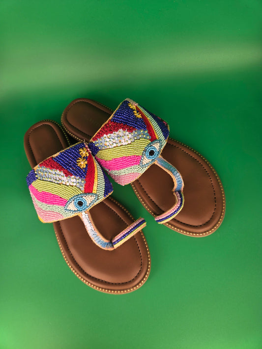 Vibrant, multicolored beaded straps featuring evil eye motif which evoke the refreshing imagery of a desert oasis, blending earthy, sun-baked textures with vibrant, life-giving pops of color.